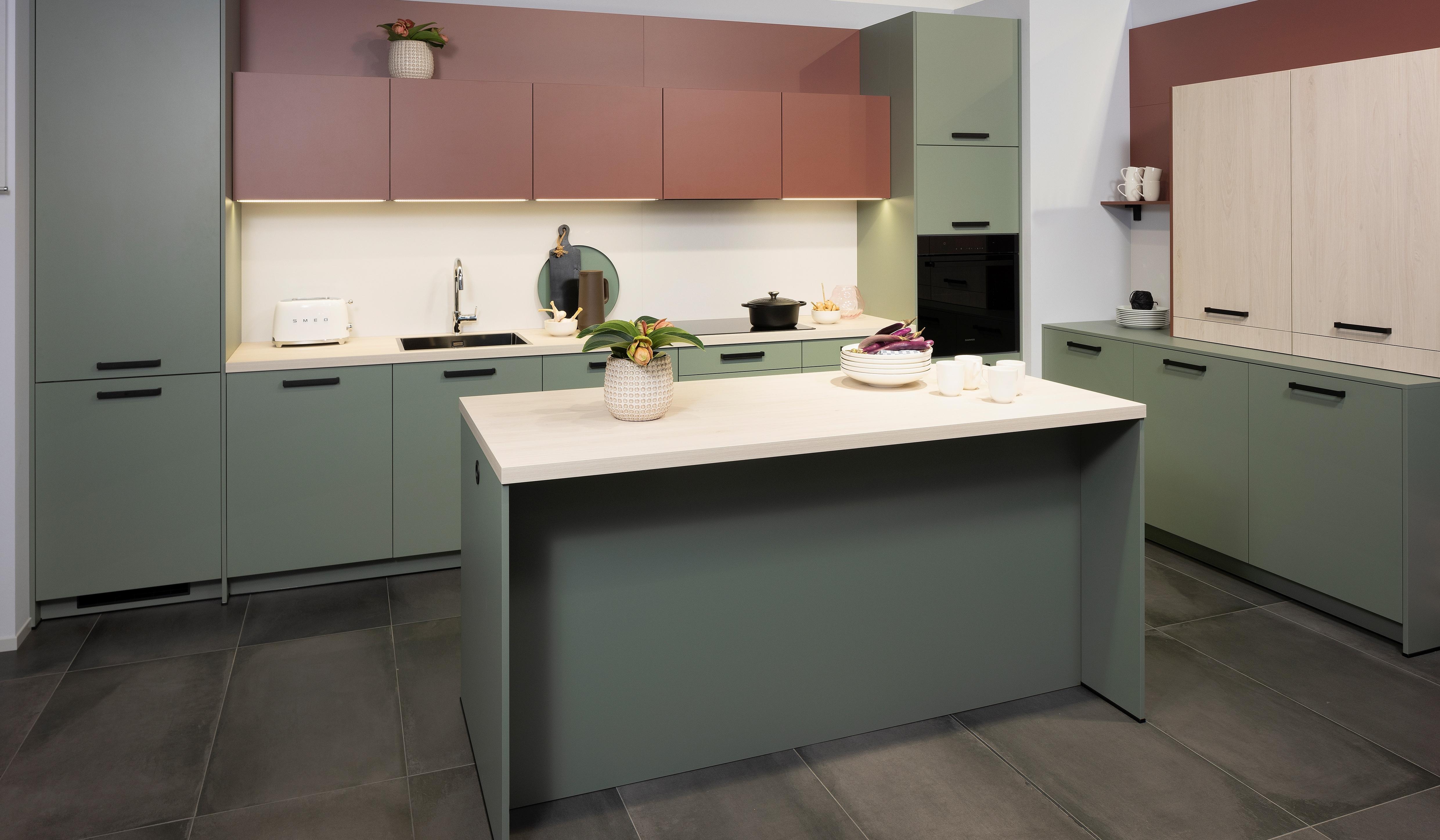 APL: White Oak Front: Pastell Eukalyptus Front: Pastell Oxidrot Korpus: Seidengrau Griff: Bügelgriff Geräte: Daewoo Armatur: Ukinox Spüle: Ukinox  Features: neue Fronten in Pastell kombiniert, neuer Haubenschrank für Dunstabzug, Handtuchhalter-Auszug, eingekofferte Wandschränke mit Klappe.