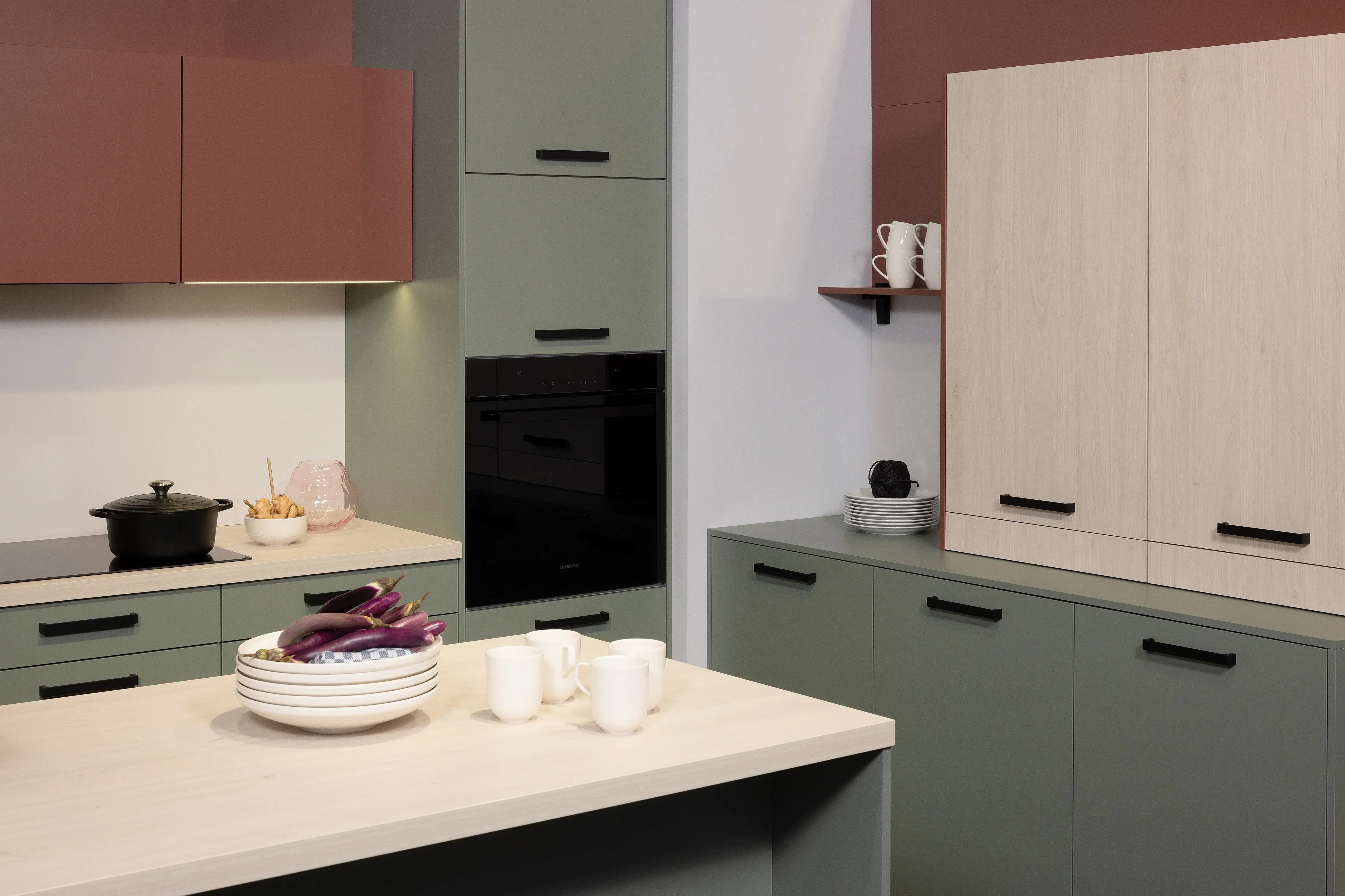 APL: White Oak Front: Pastell Eukalyptus Front: Pastell Oxidrot Korpus: Seidengrau Griff: Bügelgriff Geräte: Daewoo Armatur: Ukinox Spüle: Ukinox  Features: neue Fronten in Pastell kombiniert, neuer Haubenschrank für Dunstabzug, Handtuchhalter-Auszug, eingekofferte Wandschränke mit Klappe.